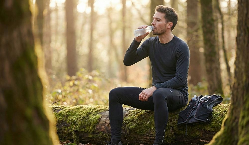Coureur assis qui boit de l'eau
